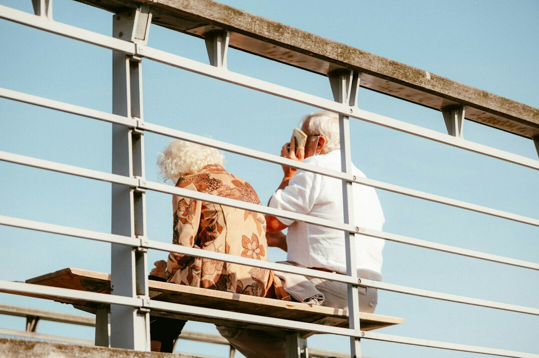Senior couple sitting together reviewing paperwork and calculating their budget