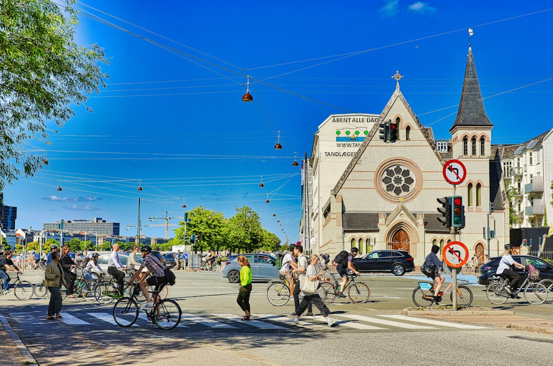 Cyclists riding along a dedicated bike lane in a Danish city street